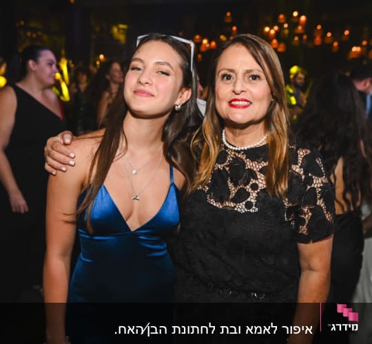 שתי נשים מחייכות באירוע חברתי עם שמלות אלגנטיות